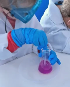 Dziecko w okularach ochronnych wykonujące eksperyment chemiczny