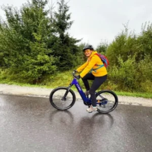 Turysta jadący na rowerze z wypożyczalni Fun Time po ścieżce rowerowej przy wejściu do Doliny Chochołowskiej w Witowie