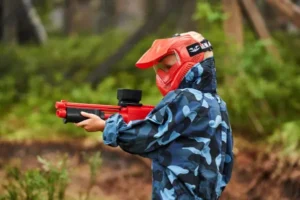 Paintball Paintdoo w Zakopanem – osoba trzymająca marker paintballowy w lesie