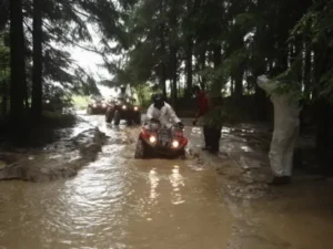 Quad wjeżdżający na zalaną wodą polną drogę w terenie