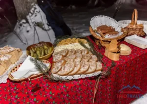 Stół ze swojskimi wyrobami, kiełbasami, ogórkami kiszonymi i chlebem ze smalcem